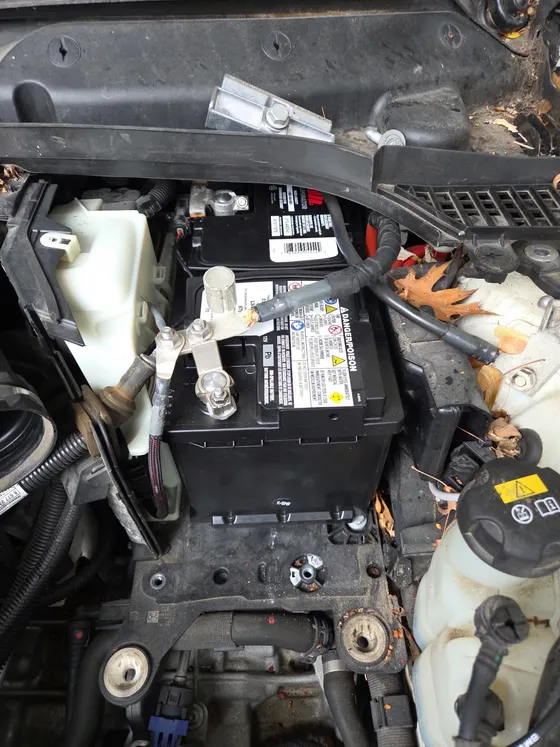 Open engine bay during a driveway service call, coolant reservoir and battery accessible from above